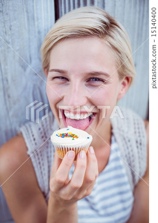 Pretty blonde woman tasting the cupcake Pretty blonde woman tasting the cupcake 15140400