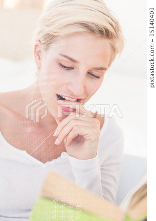 Smiling blonde woman reading a book Smiling blonde woman reading a book 15140401