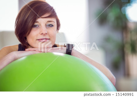 Fit woman leaning on exercise ball 15140991