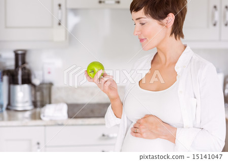 Pregnant woman eating an apple 15141047