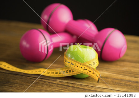 Pink dumbbells with green apple and measuring tape 15141098