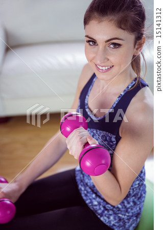 Fit woman lifting dumbbells on exercise ball Fit woman lifting dumbbells on exercise ball 15141312