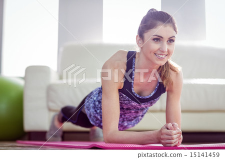 Fit woman planking on exercise mat 15141459