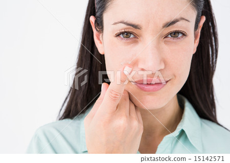 Brunette holding contact lens and smiling at camera Brunette holding contact lens and smiling at camera 15142571