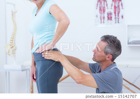 Physiotherapist examining his patient back 15142707