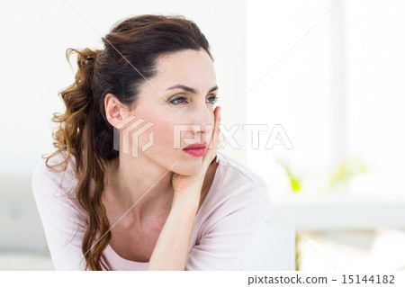 Sad brunette sitting on the couch Sad brunette sitting on the couch 15144182