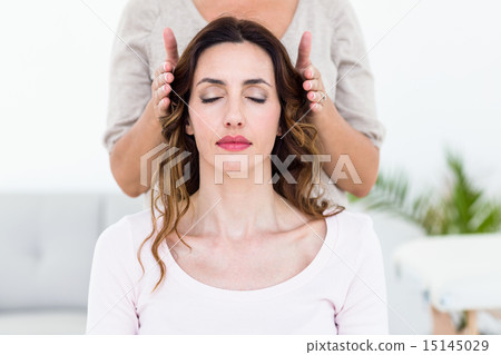 Calm woman receiving reiki treatment 15145029