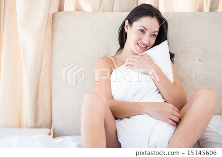 Pretty brunette smiling on bed 15145606
