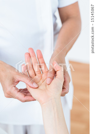 Physiotherapist examining her patients hand 15145867
