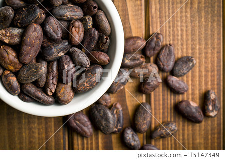 图库照片: cocoa beans in bowl on wooden table