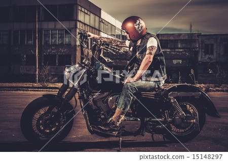 Biker and his bobber style motorcycle on a city streets Biker and his bobber style motorcycle on a city streets 15148297