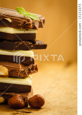 Stack of different sorts chocolate and hazelnuts Stack of different sorts chocolate and hazelnuts 15151073