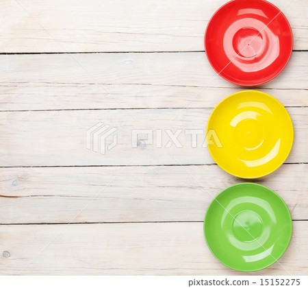 Colorful plates over white wooden table background 15152275