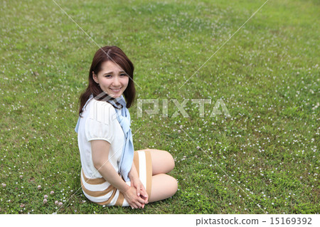 一個女人坐在草坪上 一個女人坐在草坪上 15169392