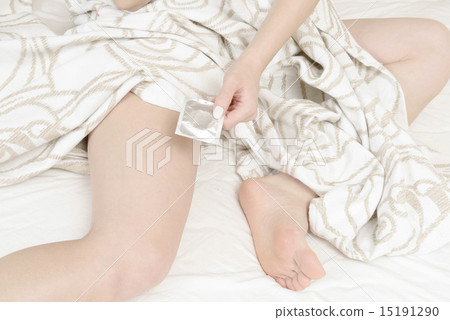 A hand of a young woman with a condom 15191290