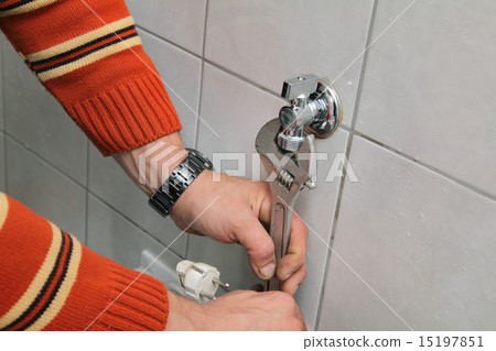 Plumbing, plumber fixing water  tap with spanner 15197851