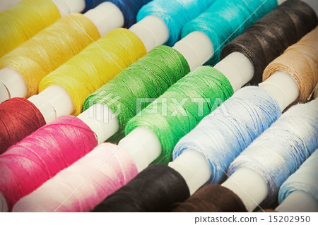 Multicolor sewing threads on wooden background Multicolor sewing threads on wooden background 15202950