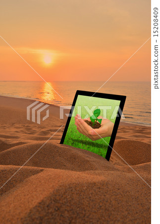 A picture of a hand holding seedlings on a tablet PC. Image of environmental problems. A picture of a hand holding seedlings on a tablet PC. Image of environmental problems. 15208409