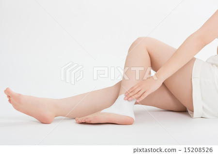 把膏藥放在她的腳踝上的女人 把膏藥放在她的腳踝上的女人 15208526