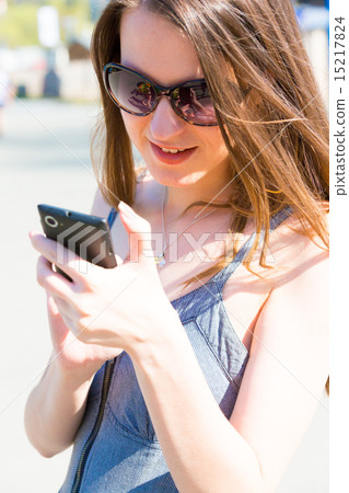 Young woman in sunglasses and summer dress used smartphone or ce 15217824