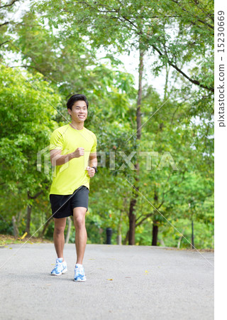 Young Chinese man running in a park 15230669