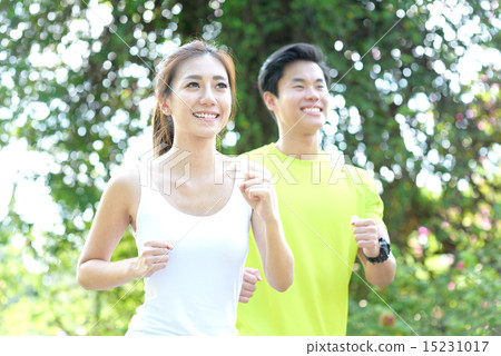 Young Chinese man and woman running in a park 15231017