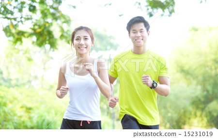 Young Chinese man and woman running in a park Young Chinese man and woman running in a park 15231019