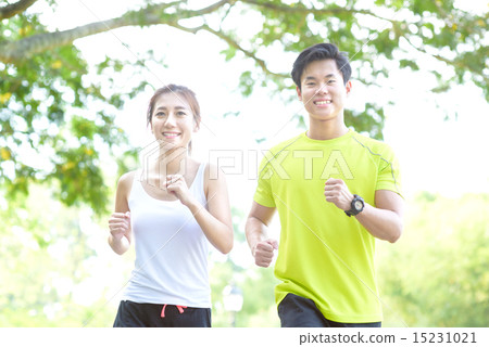 Young Chinese man and woman running in a park Young Chinese man and woman running in a park 15231021