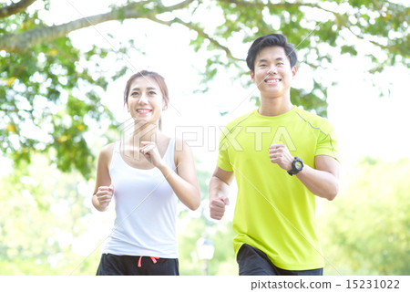 Young Chinese man and woman running in a park Young Chinese man and woman running in a park 15231022