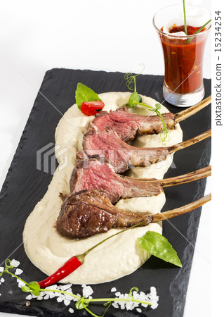 lamb ribs cooked on the grill served on a hot ston 15234254