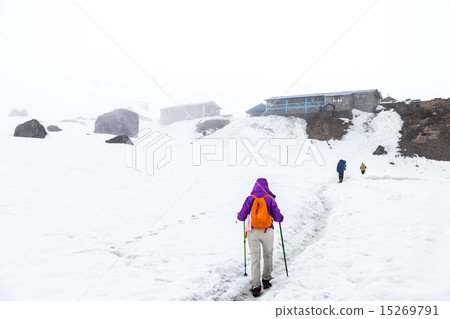 Female hiking on snow trail towards base camp 15269791