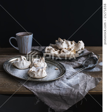 White meringue and mug of hot chocolate on a rustic wooden table. Black backdro White meringue and mug of hot chocolate on a rustic wooden table. Black backdro 15271838
