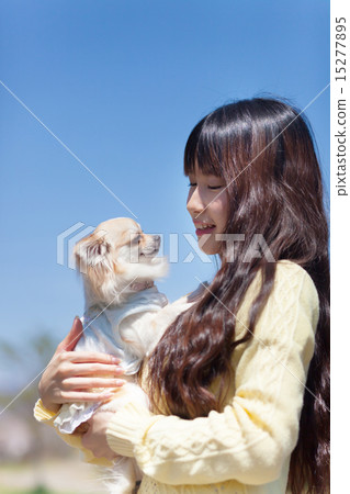 A girl holding a dog 15277895