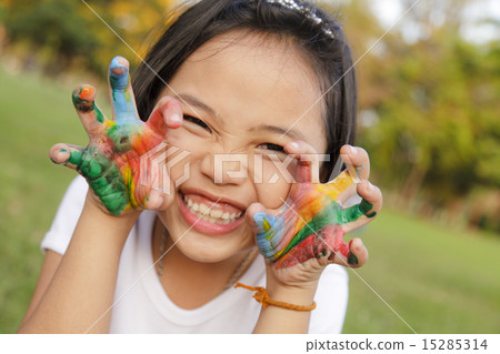 Asian little girl with hands painted in colorful paints Asian little girl with hands painted in colorful paints 15285314