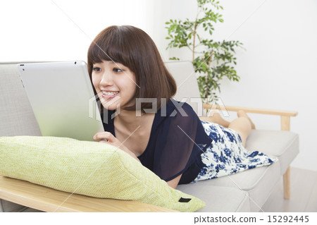 A young woman using a tablet on a sofa 15292445