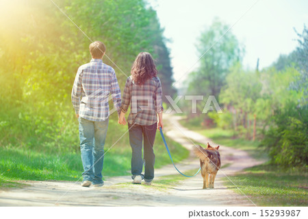 Young couple walking with dog in the village 15293987