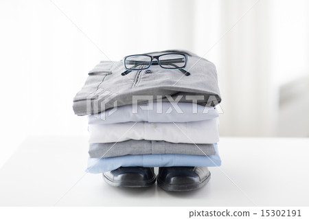close up of folded male shirts and shoes on table close up of folded male shirts and shoes on table 15302191