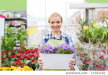 happy woman holding flowers in greenhouse happy woman holding flowers in greenhouse 15303282