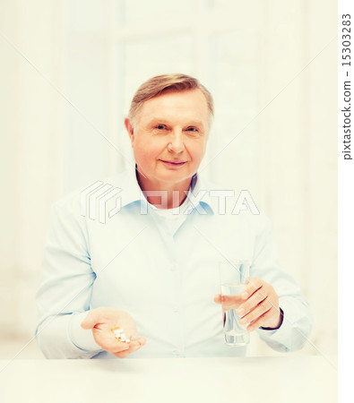 old man with pills ang glass of water 15303283