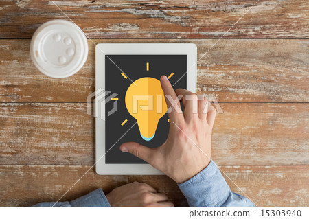 close up of hands with ligting bulb on tablet pc close up of hands with ligting bulb on tablet pc 15303940