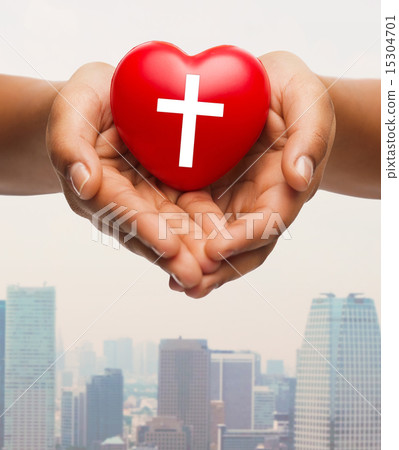 close up of hands holding heart with cross symbol 15304701