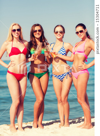 group of smiling young women drinking on beach group of smiling young women drinking on beach 15304711