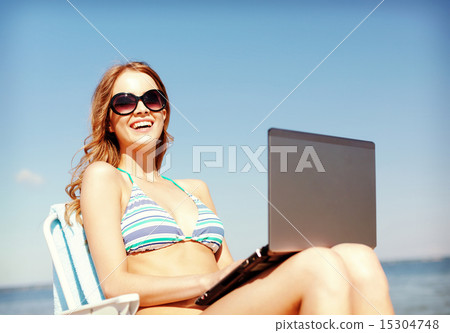 girl looking at tablet pc on the beach 15304748