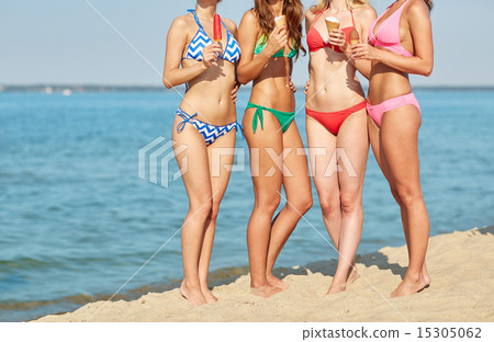 close up of young women with ice cream on beach close up of young women with ice cream on beach 15305062