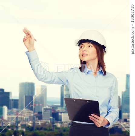 smiling businesswoman in helmet with clipboard smiling businesswoman in helmet with clipboard 15305710