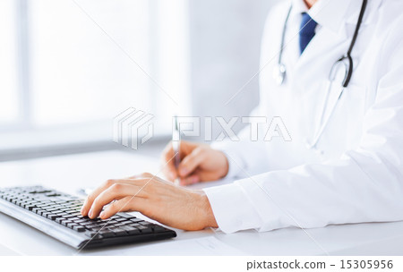 male doctor typing on the keyboard male doctor typing on the keyboard 15305956