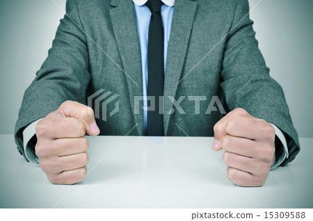 man in suit banging his fists on a desk 15309588