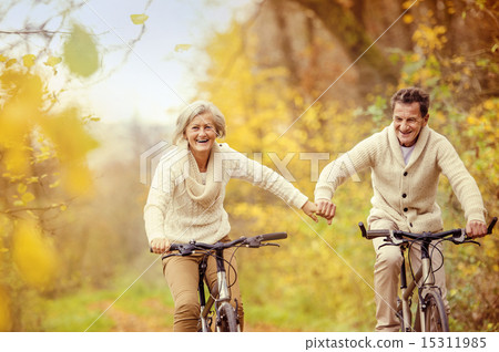 Stock Photo: Active seniors riding bike