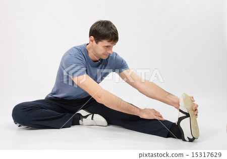 The young man stretches muscles of left leg The young man stretches muscles of left leg 15317629