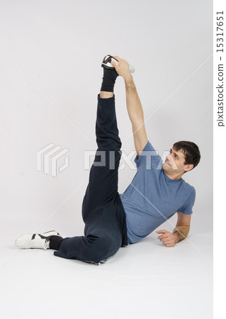 Athlete stretches muscles of legs by raising Athlete stretches muscles of legs by raising 15317651